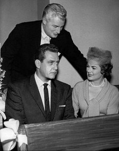 File: Photo of William Hopper (Paul Drake-standing), Raymond Burr (Perry Mason) and Barbara Hale (Della Street).  By CBS Television (eBay item photo front photo back) [Public domain], via Wikimedia Commons