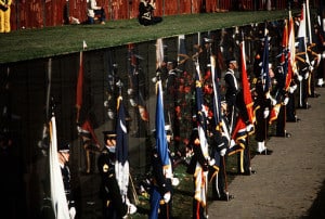 A joint services color guard displays state flags during the dedication of the Vietnam Veterans Memorial.    Attribution by Mickey Sanborn [Public domain], via Wikimedia Commons.  File:Dedication of Vietnam Veterans Memorial 1982 DF-ST-84-11922.JPEG. 