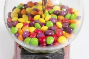 Image of candy in gumball type machine for Candy Themed Stationery Accessories blog post