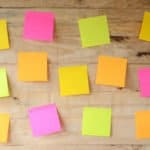 My blog post on Sticky Notes Letter Writing - image of empty colorful sticky notes on wooden bulletin board, ready for message